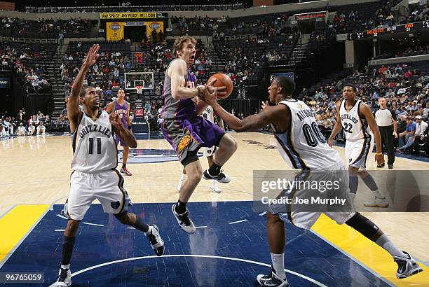 Goran Dragic of the Phoenix Suns looks to pass against Darrell Arthur and Mike Conley of the Memphis Grizzlies on February 16, 2010 at FedExForum in...