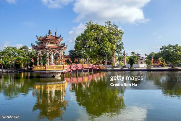 the ngoi tile-roofed bridge cross hoanh river,in centre of hai anh town,vietnam, old covered wooden bridge with tiled roof color red - hanoi fotografías e imágenes de stock