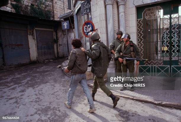 Palestinien arrêté par des soldats de Tsahal lors d'émeutes le 19 janvier 1988 à Naplouse en Israël.