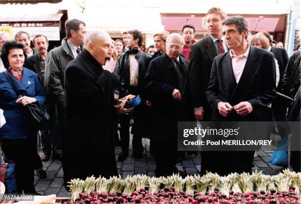François Mitterrand se promène sur un marché avec Michel Charasse et son médecin Jean-Pierre Tarot de Paris le 18 mai 1995, France.