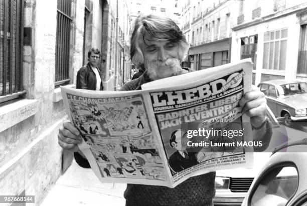 écrivain et dessinateur Cavanna lisant Hara-Kiri tout en marchant le 21 juillet 1981 à Paris, France.