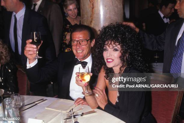 Roger Moore et Joan Collins lors d'une soirée au Festival de Cannes le 21 mai 1989, France.