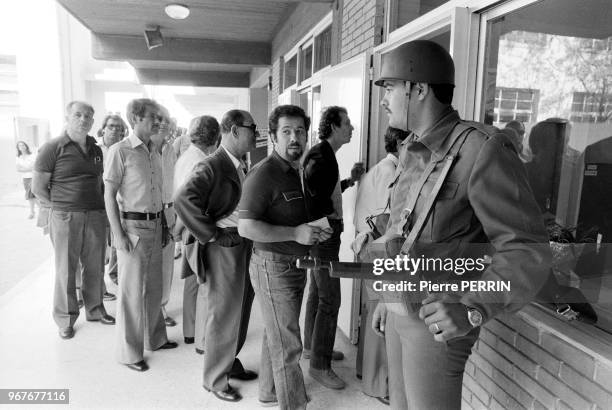 Policier en arme devant un bureau de vote lors des élections législatives le 18 octobre 1981 à Athènes, Grèce.