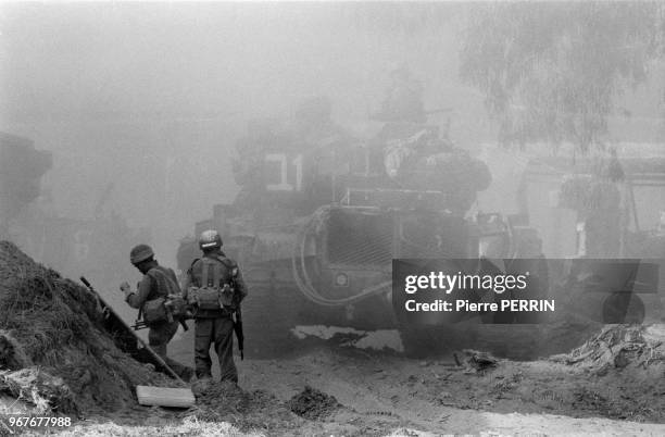 Des soldats israéliens progressent dans Beyrouth ouest accompagnés d'un blindé lors du conflit israélo-palestinien le 13 aout 1982, Liban.