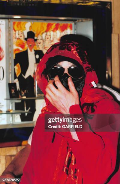 Portrait du chanteur américain Michael Jackson se couvrant le visage le 30 juin 1999 à Paris, France.