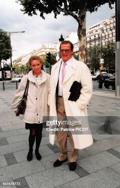 Portrait de l'acteur britannique Roger Moore et de son amie Christina Thorlstrup sur les Champs-Elysées le 13 septembre 1996 à Paris, France.