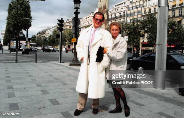 Portrait de l'acteur britannique Roger Moore et de son amie Christina Thorlstrup sur les Champs-Elysées le 13 septembre 1996 à Paris, France.