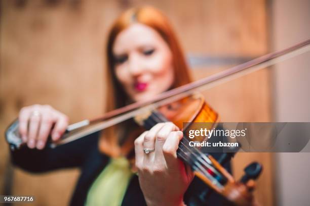 young and beautiful woman artist playing the violin on the stage. - soloist stock pictures, royalty-free photos & images