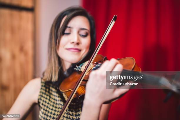 young and beautiful woman artist playing the violin on the stage. - soloist stock pictures, royalty-free photos & images