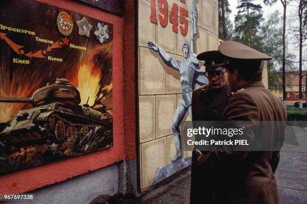 Soldats de l'armée rouge devant une affiche de propagande soviétique évoquant la Seconde Guerre mondiale le 26 avril 1991 à Berlin en RDA .