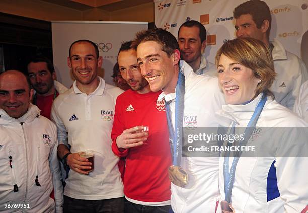 Biathlon French athletes Marie Laure Brunet and Vincent Jay drink Champagne with members of the French team as they celebrate the bronze medals of...