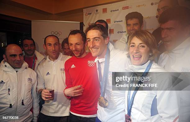 Biathlon French athletes Marie Laure Brunet and Vincent Jay drink Champagne with members of the French team as they celebrate the bronze medals of...