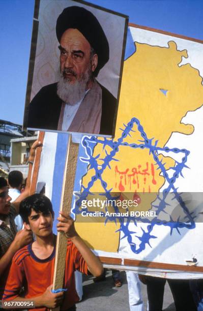 Enfant portant un panneau à l'effigie de l'ayatollah Rouhollah Khomeini lors d'une manifestation du Hezbollah contre Israël le 21 juin 1985 à...