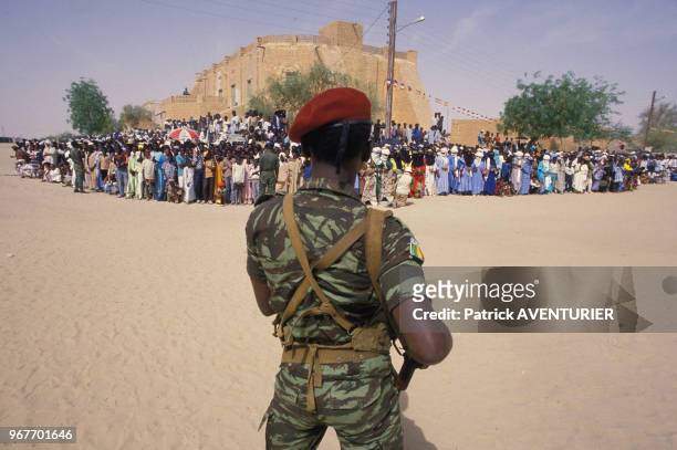 Un militaire en faction face à la population malienne venue accueillir le Président Mitterrand lors de sa visite au Mali, 17 novembre 1986, Mali.