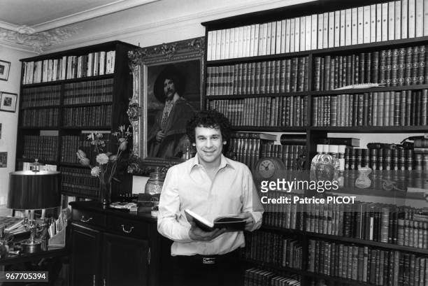 Francis Perrin devant sa bibliothèque chez lui le 19 mars 1980, France.