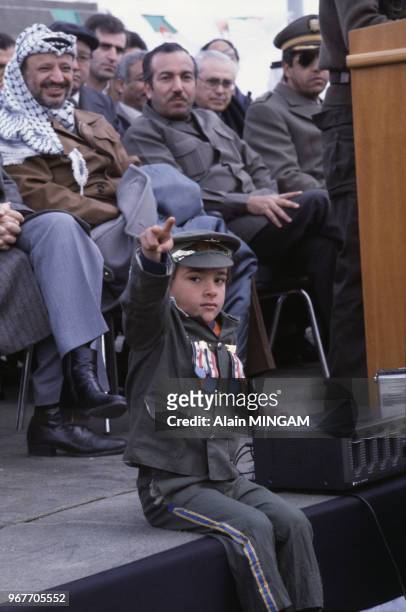 Yasser Arafat et Abou Jihad observent un enfant portant un uniforme militaire au camp palestinien de Tebessa, 19 février 1983, Tebessa, Algérie.