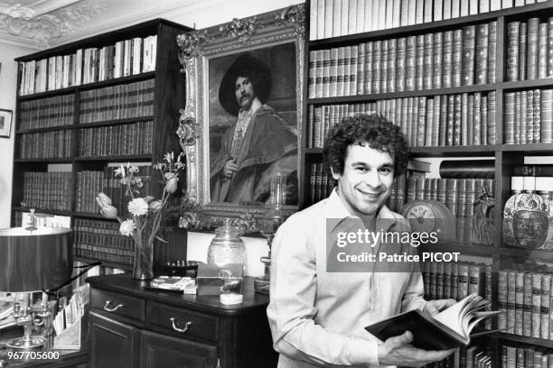 Francis Perrin devant sa bibliothèque chez lui le 19 mars 1980, France.