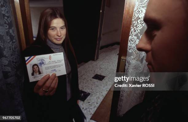 Une femme officier de recensement de la population présente sa carte à un habitant le 24 février 1999 en France.