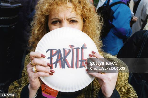 Le mot 'Parité' brandi par une femme participant à la manifestation devant le Sénat réclamant la parité en politique le 26 janvier 1999 à Paris,...