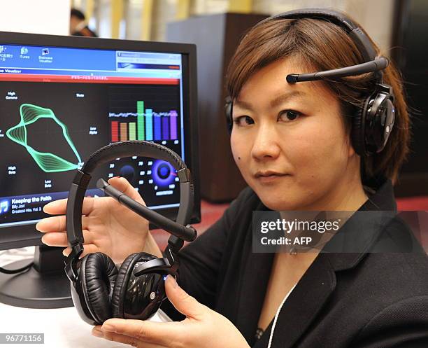 An employee of Japanese electronics manufacturer Toshiba displays a prototype model of a headset used to analyze a persons brain waves which connects...