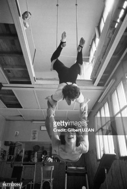 Francis Perrin et Anny Duperey répètent un numéro de trapèze le 29 avril 1975 à Paris, France.