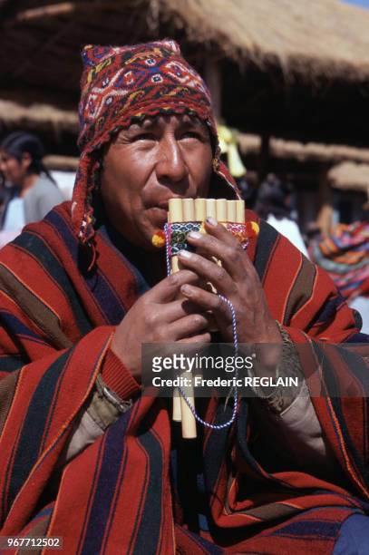 Un homme en costume traditionnel joue de la flûte de Pan en novembre 1999, Pérou.
