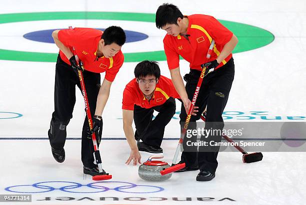 Jialiang Zang of China releases his stone down the sheet during the men's curling round robin game between China and France on day 5 of the Vancouver...