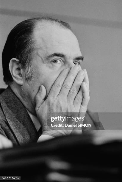 Portrait de François Mitterrand cachant son visage avec ses mains lors d'un congrés du Parti socialiste le 15 décembre 1973 à Paris, France.