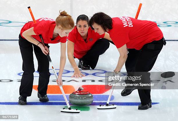 Melanie Robillard of Germany releases the stone between teammates Stella Heiss and Monika Wagner of Germany during the women's curling round robin...