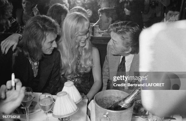 Johnny Hallyday, Sylvie Vartan et Kirk Douglas lors d'un dîner chez Maxim's le 28 septembre 1971 à Paris, France.