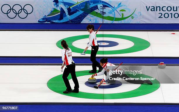 Nkeiruka Ezekh of Russia releases the stone as teammates Ekaterina Galkina and Anna Sidorova look on during the women's curling round robin game...