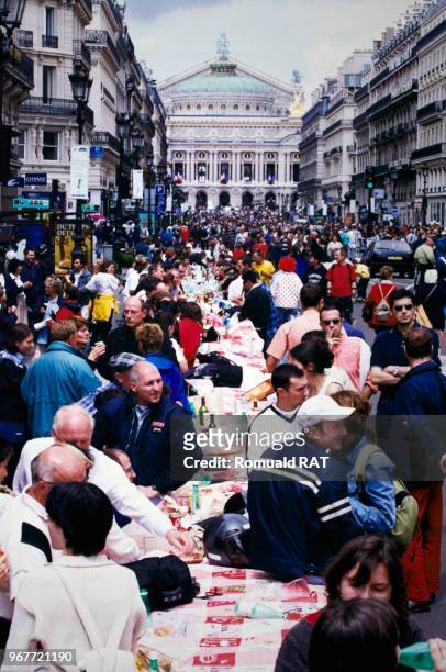 Parisiens mangeant dans la rue dans le quartier de l'Opéra lors de 'l'incroyable pique-nique' organisé lors de la fête nationale le 14 juillet 2000 à...