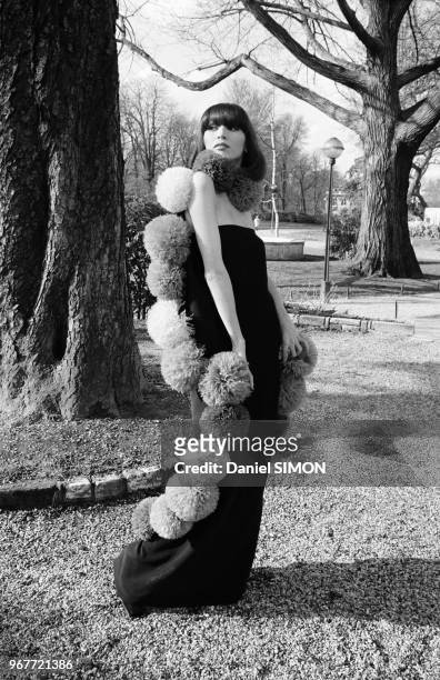 Mannequin présentant une robe Pierre Cardin en mousseline noire bordée de pompoms en plumes d'autruche de couleurs vives, collection été en janvier...