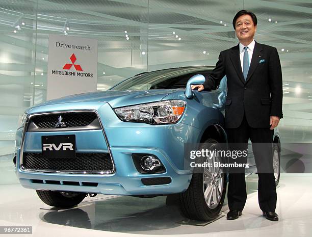 Osamu Masuko, president of Mitsubishi Motors Corp., poses with the company's RVR compact sport utility vehicle during the unveiling in Tokyo, Japan,...