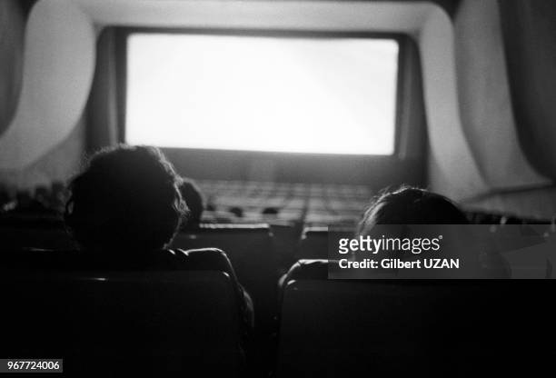 Spectateurs regardant un écran dans une salle de cinéma à Paris le 16 mai 1977, France.