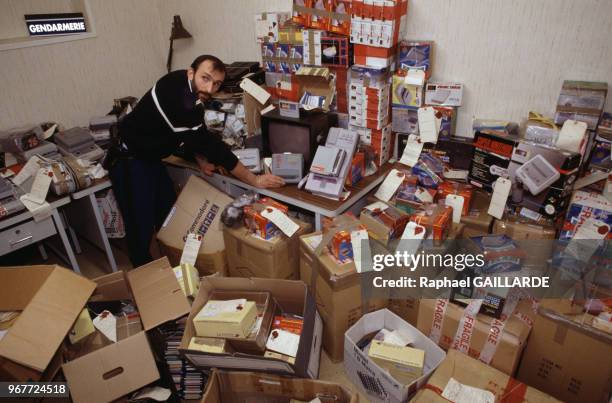 Un policier lors d'une saisie de materiel informatique pour piratage de jeux vidéo Nintendo à Paris le 21 décembre 1994, France.