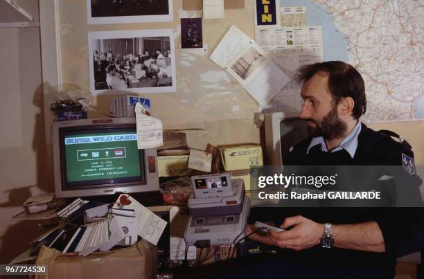 Un policier lors d'une saisie de materiel informatique pour piratage de jeux vidéo Nintendo à Paris le 21 décembre 1994, France.