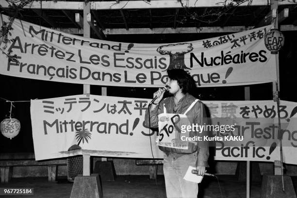Un manifestant japonais conteste avec des banderoles en français et en japonais les essais nucléaires français dans le Pacifique lors du voyage...