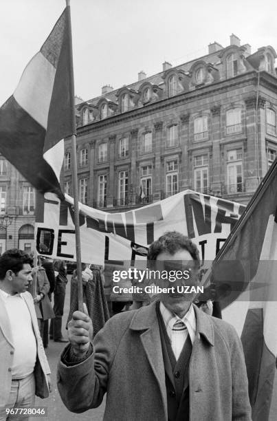 Harki tenant un drapeau français lors d'une manifestation devant le ministère de la Justice le 30 avril 1976 à Paris, France.