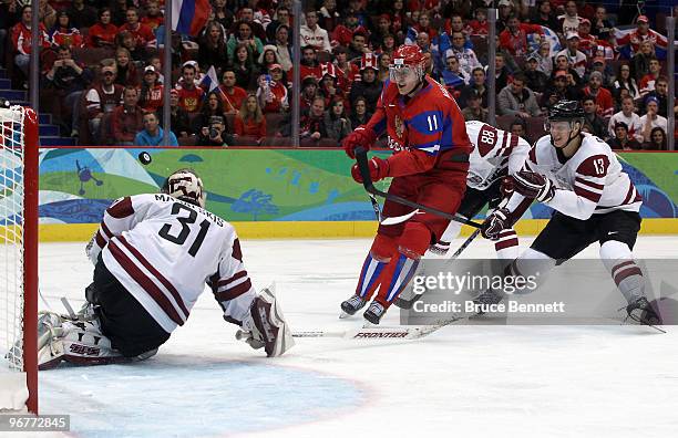 Evgeni Malkin of Russia has his shot on goal saved by Edgars Masalskis of Latvia during the ice hockey men's preliminary game between Russia and...