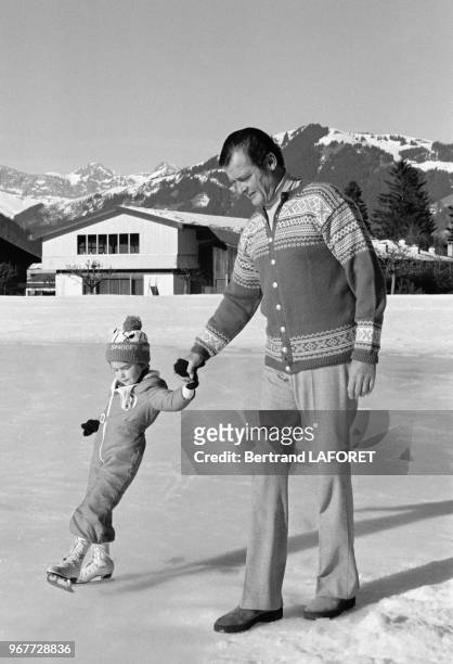 Roger Moore et sa fils Christian à la patinoire à Gstaad le 20 décembre 1977, Suisse.