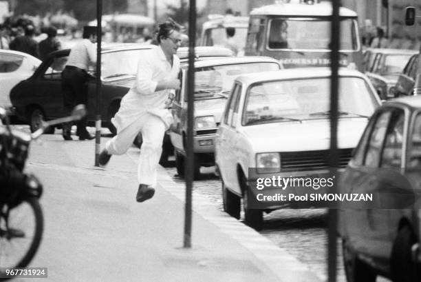 Un infirmier coure se mettre à l'abris lors de la prise d'otages à l'ambassade d'Irak par un membre de l'OLP à Paris le 31 juillet 1978. Un policier...