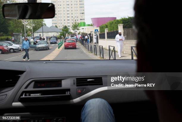 Un policier du Renseignement Territorial dans une voiture, surveille les abords d'une mosquée dont certains fidèles sont soupçonnés de radicalisation...