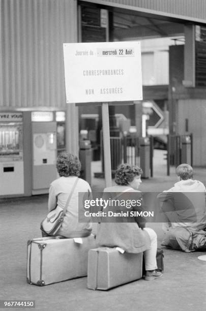 Passagers assis sur leurs valises à la Gare Saint-Lazare lors d'une grève de la SNCF le 22 aout 1979, Paris, France.