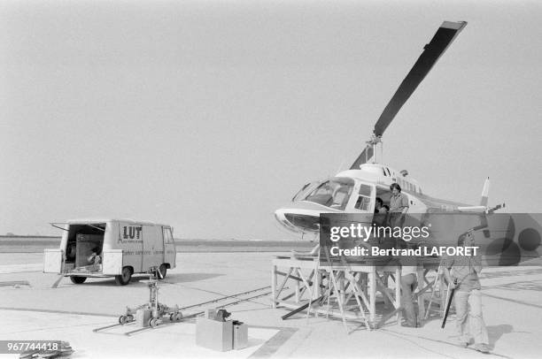 Techniciens s'affairant près d'un hélicoptère sur le tournage du film 'Le Gagnant' à Paris le 31 aout 1979, France.