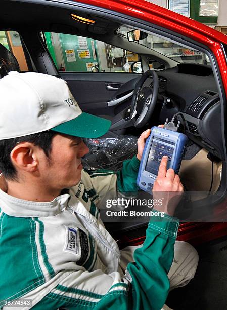 An engineer uses a "Ta-SCAN" device to install new Antilock Braking System software on a recalled Toyota Motor Corp.'s third-generation Prius hybrid...