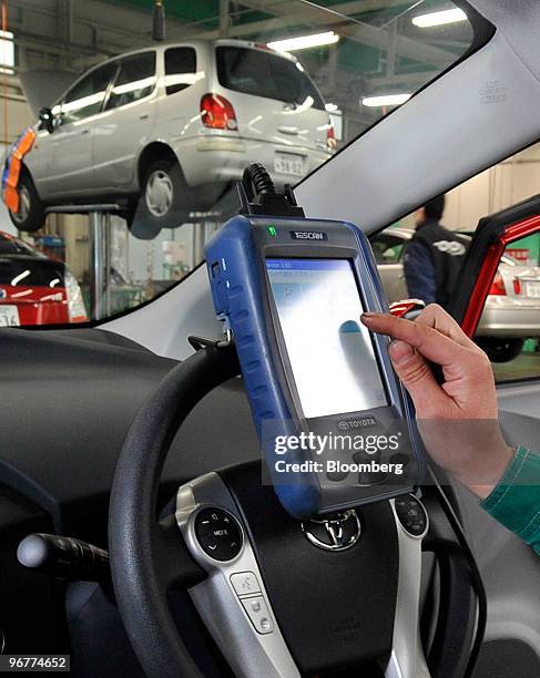 An engineer uses a "Ta-SCAN" device to install new Antilock Braking System software on a recalled Toyota Motor Corp.'s third-generation Prius hybrid...