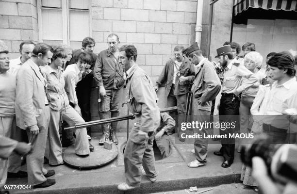 Les policiers remontent des égoûts le matériel de terrassement utilisé par des cambrioleurs pour vider les coffres d'une banque le 17 août 1976 à...