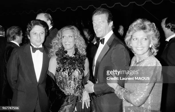 Michel Drucker, Roger Moore et son épouse Luisa, et Dalida lors d'une soirée au château de Versailles le 17 septembre 1981, France.