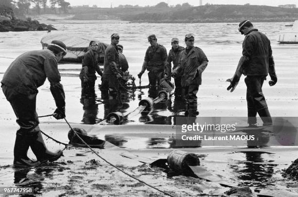 Equipe de militaires nettoyant la plage après le naufrage du pétrolier Amoco Cadiz le 21 mars 1978 à Portsall, France.